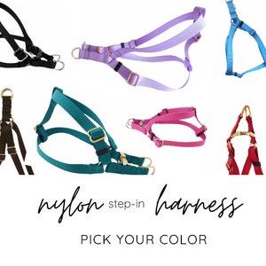 May include: Six nylon step-in harnesses in different colors: black, purple, teal, pink, blue, and red.  "nylon step-in harness PICK YOUR COLOR" text is at the bottom of the image.