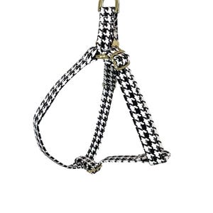 Peut inclure: Un harnais pour chien en tissu noir et blanc &agrave; motif pied-de-poule avec des accessoires dor&eacute;s.