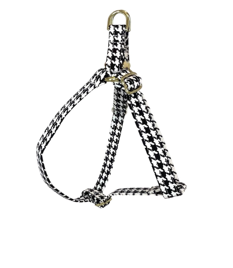 Peut inclure: Un harnais pour chien en tissu noir et blanc &agrave; motif pied-de-poule avec des accessoires dor&eacute;s.