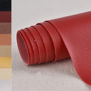 May include: A rolled-up sheet of red faux leather with a textured surface. The image also shows a color swatch of various leather colors, including black, brown, tan, and cream.