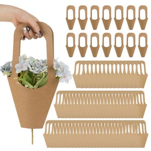 Peut inclure: Un panier à fleurs en papier kraft rempli de fleurs bleu clair, tenu par une main. Des porte-fleurs et des plateaux en papier kraft supplémentaires sont également présentés. Le panier a une poignée et un fond pointu. Les plateaux ont un bord festonné.