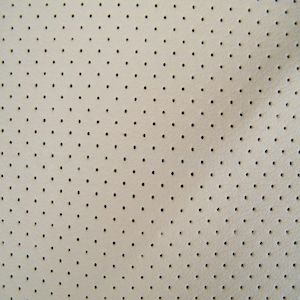 May include: Close-up of a cream-colored, perforated leather material. The surface is evenly dotted with small, black circular perforations. The texture appears smooth with a subtle sheen, suggesting a high-quality finish. The pattern is consistent across the entire view.