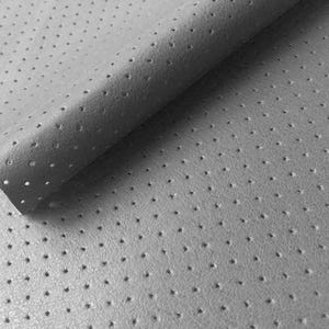 May include: Close-up of a gray perforated leather material. The leather has a matte finish and is dotted with small, evenly spaced holes. The material is folded over, revealing the underside.