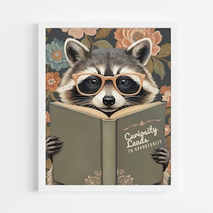 May include: A wall art print featuring a raccoon wearing light orange glasses while reading an open book. The book cover is sage green with the text Curiosity Leads TO OPPORTUNITY. The background displays a dark floral pattern with orange and blue flowers.