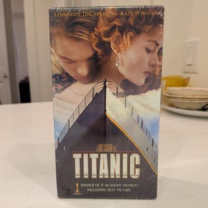 May include: A VHS tape of the film "Titanic" starring Leonardo DiCaprio and Kate Winslet. The cover art features the actors and a ship illustration. Text includes "Winner of 11 Academy Awards including Best Picture."