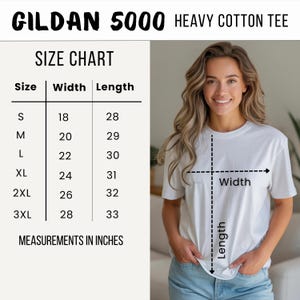 Pode incluir: Uma camiseta branca Gildan 5000 de algod&atilde;o pesado com uma tabela de tamanhos. A tabela mostra as medidas em polegadas, equivalentes em cm, para largura e comprimento, do tamanho P ao 3XL. A modelo est&aacute; vestindo a camiseta branca.