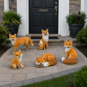 May include: A collection of five fox figurines in various poses, including standing, sitting, and curled up. Each fox features realistic orange and white fur textures, pointed ears, and bushy tails, crafted as decorative garden statues for outdoor display.