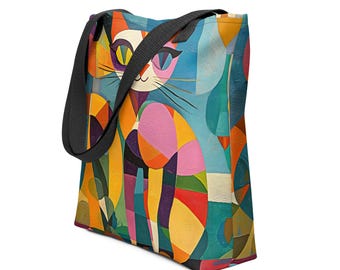 May include: A colorful tote bag featuring a geometric cat design. The artwork uses a vibrant palette of blues, oranges, pinks, and yellows. The bag has a black strap and is likely made of durable fabric, suitable for carrying items.