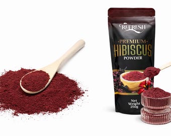 May include: A pile of deep red hibiscus powder with a wooden spoon, and a bag of Refresh Premium Hibiscus Powder. The bag has a black background with gold lettering and a net weight of 250g.
