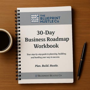 May include: A spiral-bound workbook titled "30-Day Business Roadmap Workbook" with the text "The Blueprint Hustle Co." on the cover. A black pen and a cup of coffee sit beside the workbook on a wooden surface.