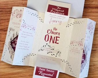 May include: A folded cream-colored invitation card featuring maroon text and illustrations of a castle. The text reads: Your Magical Presence, Avery, The Chosen One, Saturday 27th September, from 11am to 2pm, and has been requested. Footprints decorate the paper.