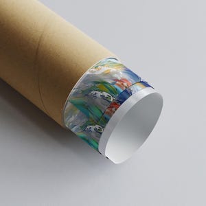 May include: A rolled-up poster in a brown cardboard tube. The edge of the poster displays a colorful abstract painting with blue, green, red, and white brushstrokes. The tube is on a white surface.