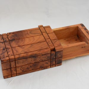 Op de afbeelding: Een handgemaakte houten snijplank met een natuurlijke houtnerf. De plank heeft een sapgroef en een handvat. Afmetingen: ongeveer 45 cm lang, 30 cm breed en 2,5 cm dik.