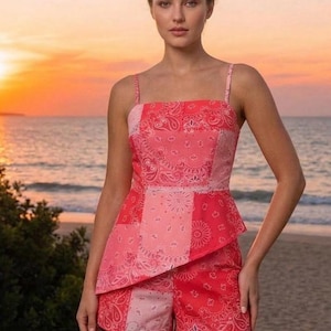May include: A sleeveless peplum top and matching shorts set featuring a patchwork bandana print in various shades of pink and red. The top has thin shoulder straps and a square neckline, while the shorts feature a consistent pattern design.