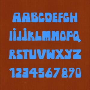 May include: A brown background with blue text displaying the alphabet and numbers in a chunky, 1970s-style font. The text at the top reads "A CHUNKY 1970'S LOOKING FONT" and the text at the bottom reads "INSPIRED BY ROCKS & VALLEYS".