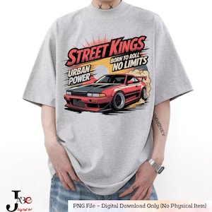 Puede incluir: Una camiseta gris con un gráfico de un coche deportivo rojo y el texto "STREET KINGS, BORN TO ROLL, NO LIMITS, URBAN POWER." El coche se representa con humo y un fondo de puesta de sol. La camiseta tiene mangas cortas.