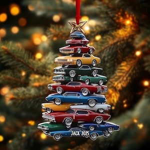 May include: A Christmas tree ornament shaped like a tree, composed of stacked classic cars in various colors. The ornament is topped with a gold star and has a red ribbon for hanging. The text "JACK 2025" is at the bottom.