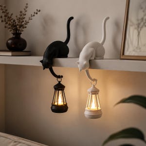Peut inclure: Deux décorations d'étagère en forme de chat, une noire et une blanche. Chaque chat est perché sur une étagère et tient une lanterne. Les lanternes émettent une lumière chaleureuse, créant une ambiance cosy.