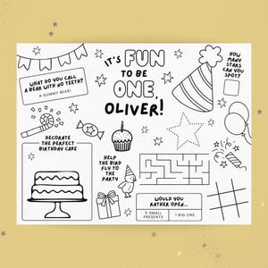 May include: Black and white activity sheet for a first birthday, featuring the text "It's Fun to be One, Oliver!" with various illustrations like a cake, party hat, and a maze. Includes prompts for coloring and activities.