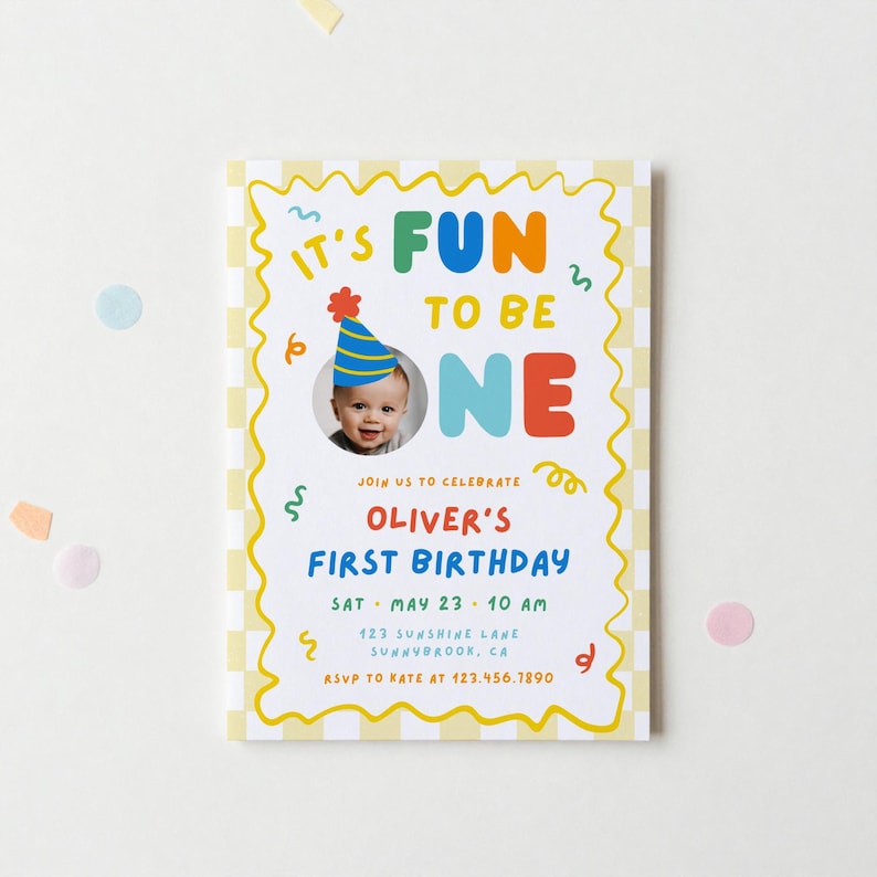 May include: A rectangular birthday invitation card with a yellow and white checkered border. The text reads IT'S FUN TO BE ONE, featuring a circular photo of a child in a party hat, followed by OLIVER'S FIRST BIRTHDAY, date, time, and address details.