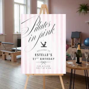 May include: A sign on an easel with the text "Pilates in pink" in elegant script. The sign has pink and white vertical stripes and includes the text "Welcome to Estelle's 21st Birthday" and event details.