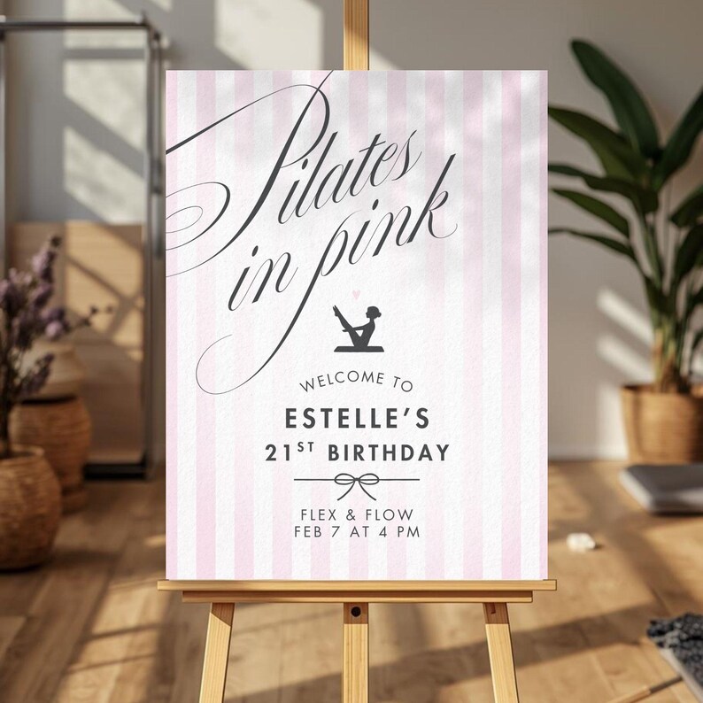 May include: A pink and white striped sign on a wooden easel. The sign reads "Pilates in pink" in elegant script, with the words "Welcome to Estelle's 21st Birthday" below. The sign also includes the text "Flex & Flow Feb 7 at 4 PM".