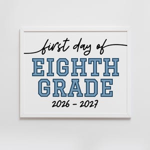 以下が含まれることがあります： 白いフレームに入ったサインで、黒い筆記体のfirst day ofという文字、その下に水色で濃い青の縁取りがされたブロック体のEIGHTH GRADEという文字、そして白い背景の下部に黒い2026 - 2027という文字が配置されています。