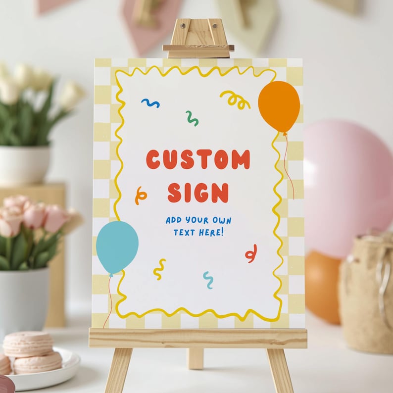 May include: A rectangular sign on a wooden easel featuring a white center with a yellow wavy border and a light yellow checkered background. The sign displays the red text CUSTOM SIGN and blue text ADD YOUR OWN TEXT HERE, with colorful balloons and confetti.