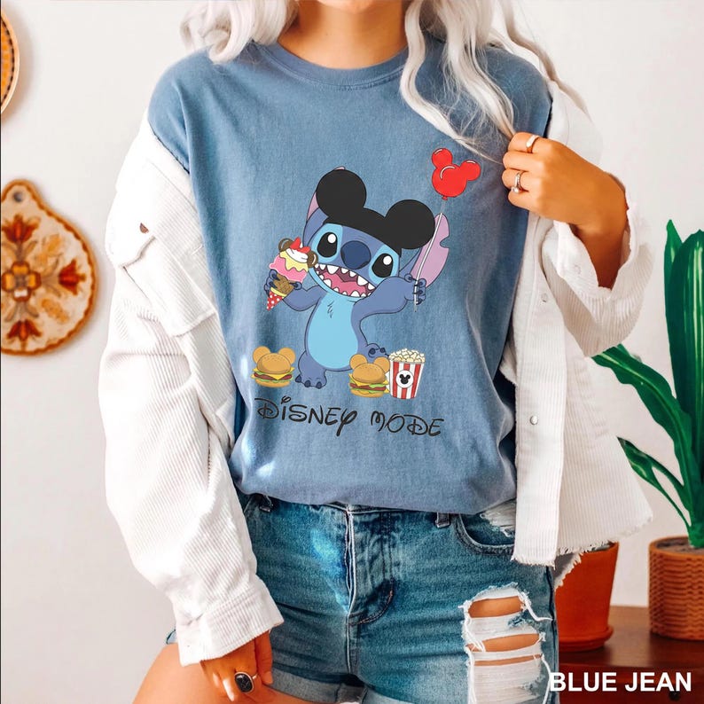 A person wearing a blue t-shirt with a Disney character graphic and the text "Disney mode" printed on it.