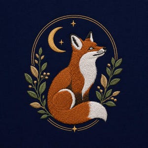 May include: An embroidery design on a dark navy fabric featuring a seated orange fox with a white chest and tail tip. The fox is framed by a gold-stitched oval border with green and gold leaves, a crescent moon, and small four-pointed stars.