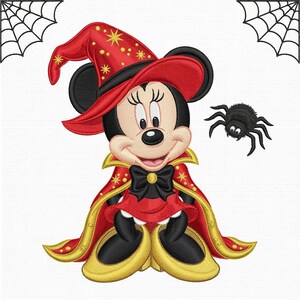 Könnte beinhalten: Ein Stickmotiv mit einer Zeichentrickmaus, die einen roten Hexenhut mit gelben Sternen, einen roten Umhang mit Goldbesatz und eine schwarze Schleife trägt. Rechts befindet sich eine kleine schwarze Spinne, in den Ecken sind Spinnennetze.