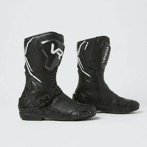 Side view of men's black Venom Racing leather motorcycle boots showing spiderweb embossed toe box carbon shin panel adjustable instep buckle strap and anti-slip rubber outsole