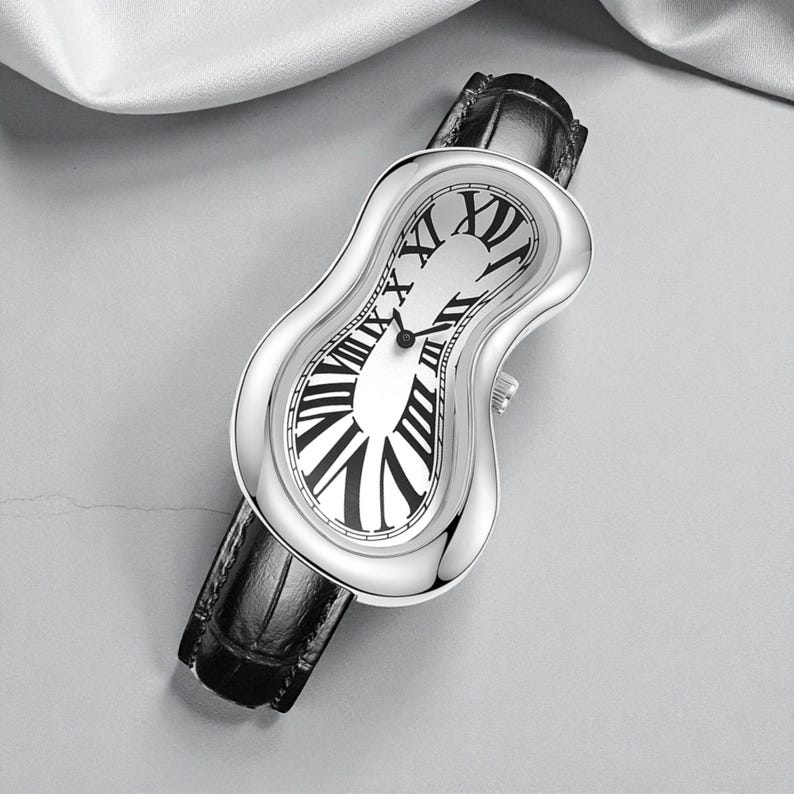 May include: A silver wristwatch with a unique, melting design. The watch face features black Roman numerals on a white background. It has a black leather band. The watch's unusual shape and design make it a statement piece.