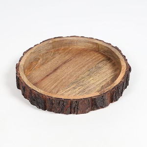 May include: A round wooden tray featuring a smooth, light brown interior surface and a thick, dark brown exterior rim that retains the natural, rough, and textured bark of the tree from which it was crafted, creating a rustic, circular wooden dish.