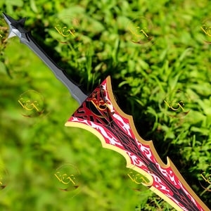 Puede incluir: Espada decorativa con una hoja roja y negra, detalles dorados y un mango plateado. La espada se muestra sobre un fondo de hierba verde, destacando su intrincado diseño y artesanía.