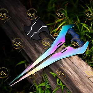 May include: Two iridescent swords with a rainbow sheen, alongside a black and white shield. The swords feature a blue handle and a blade that shifts from pink to blue. The shield is black with white detailing. The items are presented on a wooden surface.