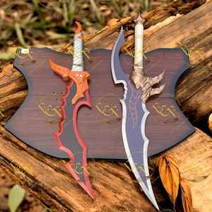 Könnte beinhalten: Zwei dekorative Fantasy-Schwerter mit kunstvollen Designs. Ein Schwert hat eine orangefarbene und schwarze Klinge mit rotem Rand, das andere eine blaue Klinge mit goldenen Akzenten. Beide sind auf einer dunklen Holzplatte montiert.