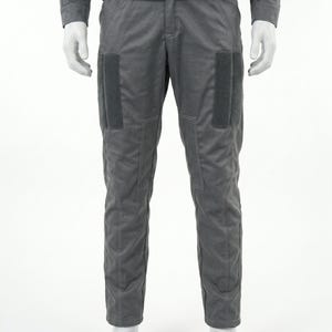 May include: Gray, two-piece outfit. The long-sleeved top and pants are a matching shade of gray. The pants have two rectangular patches on the front of each leg. The outfit is displayed on a mannequin.