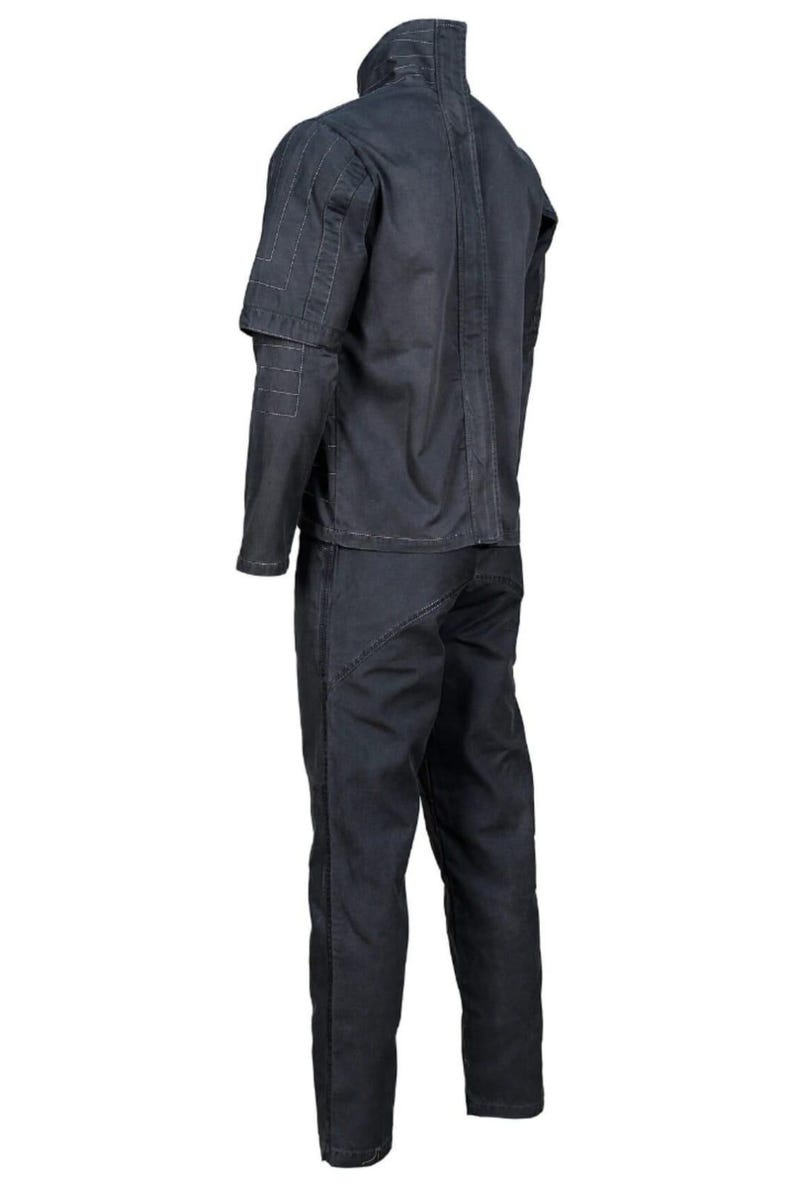 Op de afbeelding: Een donkergrijze tweedelige werkpak. De jas heeft een hoge kraag en gestikte details op de schouders en mouwen. De broek heeft rechte pijpen. Het pak is gemaakt van een duurzame stof.