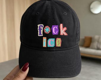 May include: Black baseball cap with the text "f*ck ice" in colorful, block letters. The hat has a curved brim and a classic, adjustable design. The text is in purple, pink, blue, orange, and green.
