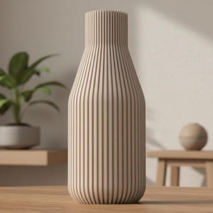 Può includere: Un vaso beige con linee verticali, a forma di bottiglia. Il vaso è realizzato in un materiale chiaro ed è posto su una superficie di legno. Sullo sfondo è visibile una piccola pianta in un vaso grigio.