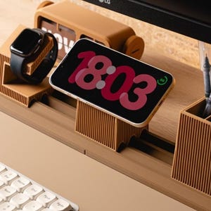 Può includere: Un organizer da scrivania marrone chiaro con uno smartwatch nero, uno smartphone che mostra l'ora 18:03 e un orologio in stile retrò. Sono visibili anche una tastiera e delle penne. L'organizer è realizzato in materiale a coste.