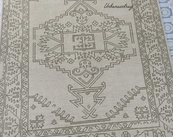 May include: Beige rectangular rug with a detailed geometric pattern in shades of brown. The rug features a central design with floral and geometric shapes, framed by a border with repeating patterns. The text "Urbanwoolrug" is visible on the rug.