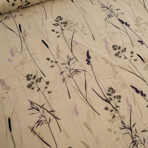 Könnte beinhalten: Cremefarbener Stoff mit einem sich wiederholenden Muster aus stilisierten Gräsern und Samenköpfen in Grau-, Lila- und Schwarztönen. Das Design erinnert an ein natürliches, botanisches Thema, geeignet für Heimtextilien oder Kleidung.