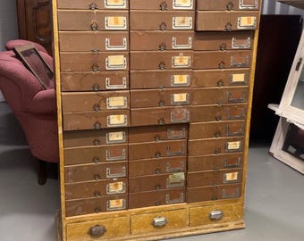 Archivador industrial francés de gran tamaño de principios del siglo XX con múltiples cajones y etiquetas originales.