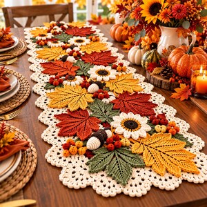 Pode incluir: Um caminho de mesa de crochê longo e retangular com uma borda festonada na cor creme e um design central de folhas de outono tridimensionais em vermelho, laranja e amarelo, folhagem verde, girassóis brancos e pequenas bolotas marrons.