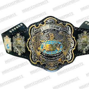 May include: A black and gold wrestling championship belt. The belt has the text "WORLD" and "AEW HEAVYWEIGHT CHAMPION". The central emblem features an eagle and globe design.