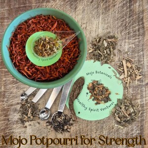 Può includere: Una ciotola turchese piena di erbe marrone-rossastre, un piccolo misurino verde e un'etichetta circolare verde con testo. Cucchiaini dosatori argentati e varie erbe essiccate sono sparsi. Il testo "Mojo Potpourri for Strength" è in basso.