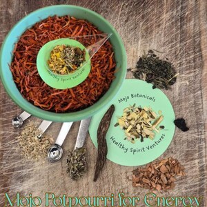 Può includere: Una ciotola turchese piena di erbe arancioni essiccate, un piccolo piatto verde con erbe miste e diversi cucchiai dosatori. Ulteriori erbe sono disposte attorno alla ciotola. Il testo "Mojo Potpourri for Energy" è in basso.