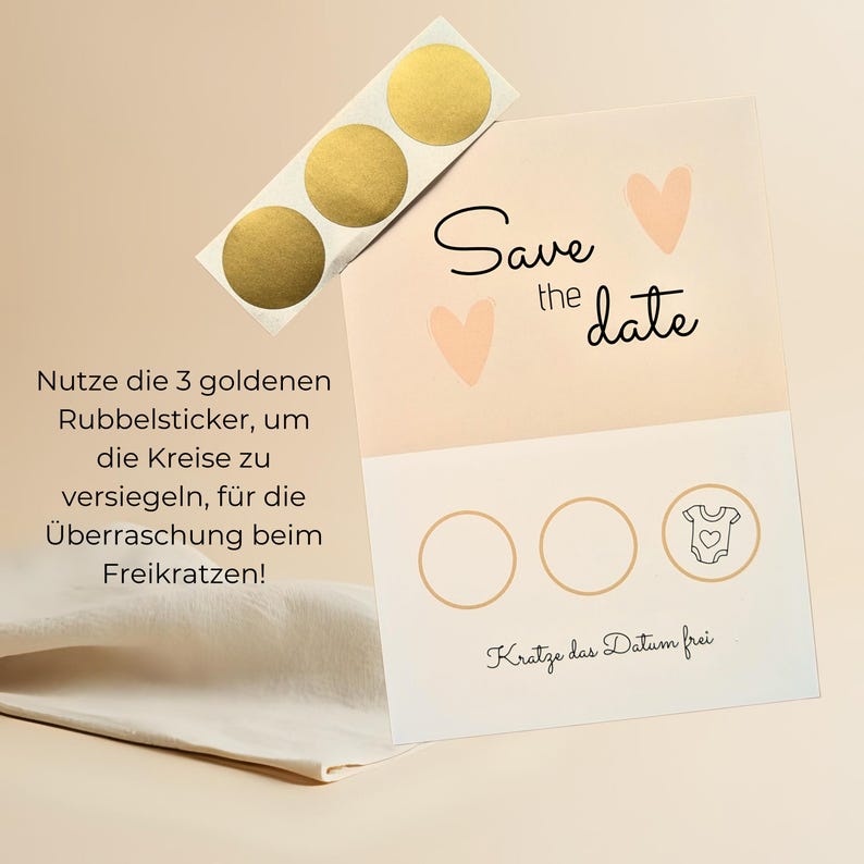 May include: A light peach-colored "Save the Date" card with two peach hearts and the text "Save the date" in black script. Three gold scratch-off stickers are included. The card has three circles and a baby onesie graphic.